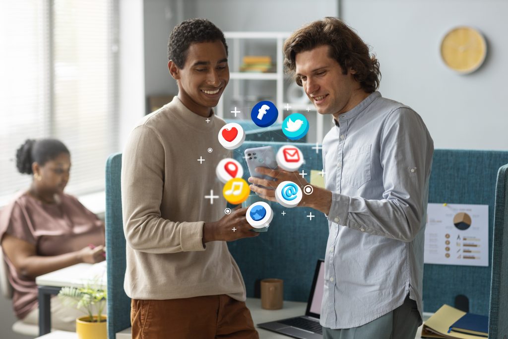 Two men exploring social media which is one of the linked with digital marketing